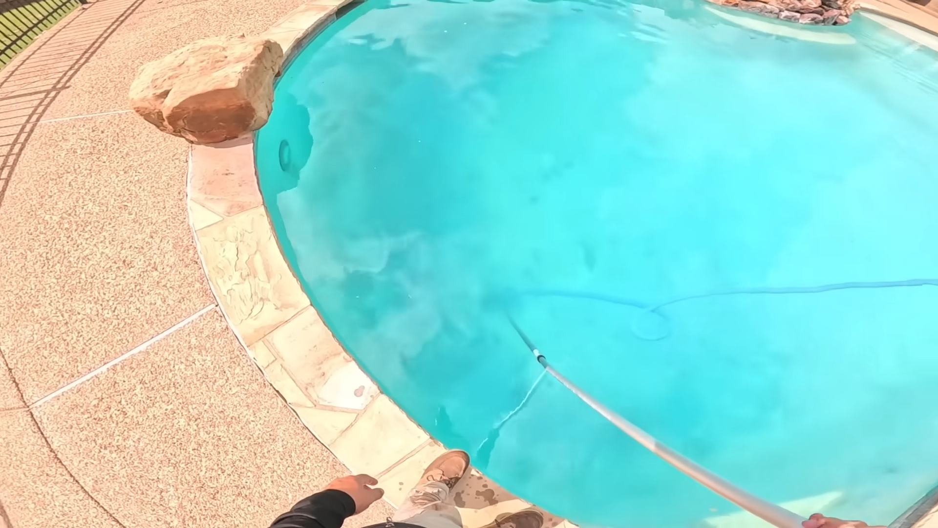 Pool technician brushing and vacuuming in Spring, TX